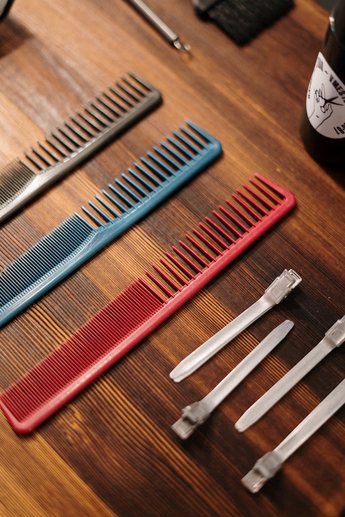 about-us-02 Close-up of various hair salon tools, including colorful combs, on a wooden surface.
