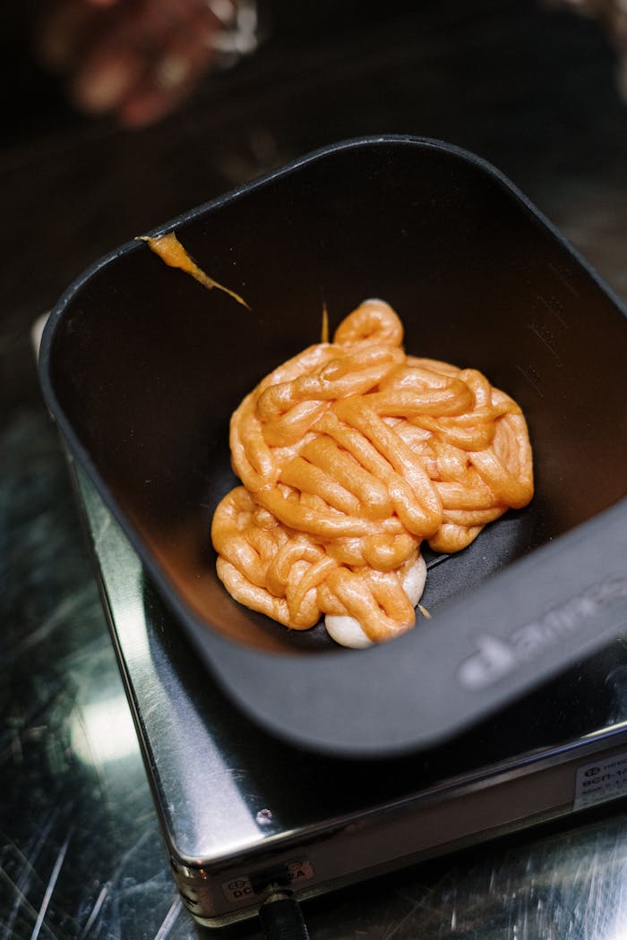 Close-up of vibrant orange hair dye in a salon mixing bowl, ready for application.