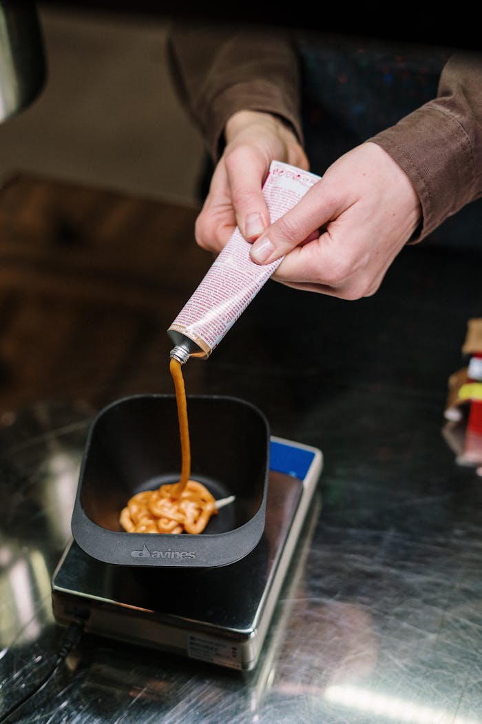 The Art of Drawing Readers In: Your attractive post title goes here Image of hair dye being squeezed into a bowl, showcasing salon preparation process.